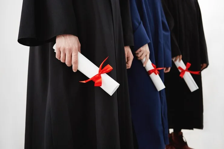 close-up-university-students-graduates-mantles-holding-diplomas_176420-14304.webp